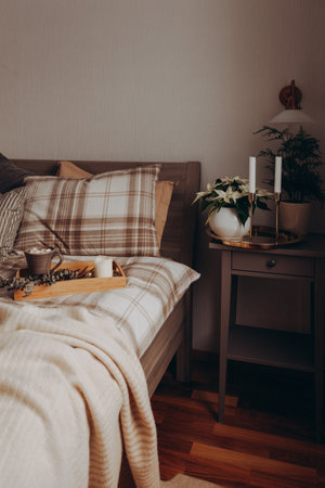 cozy scandinavian bedroom interior in natural tones, blanket candles houseplantsの写真素材