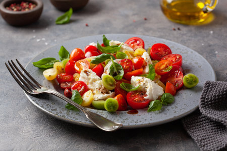 healthy colorful tomato mozzarella basil salad with balsamic vinegar dressingの写真素材