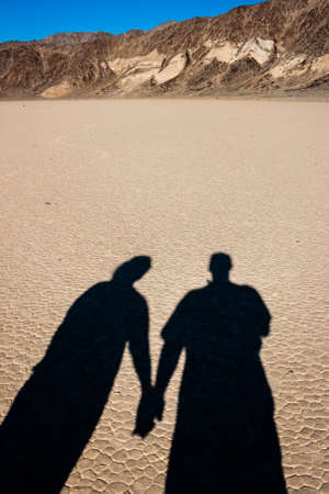 Shadows holding hands in the desertの写真素材