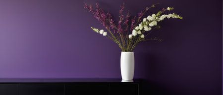 Elegant plant with white and purple flowers in a white vase, placed against a rich purple wall. Perfect for interior design and floral decor themes.の素材