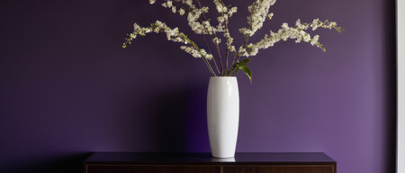 Elegant plant with white and purple flowers in a white vase, placed against a rich purple wall. Perfect for interior design and floral decor themes.の素材