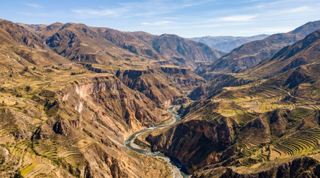 Bird s eye realistic landscape view of Colca Canyon, wide aerial panorama showing deep canyon walls, terraced slopes and broad Andean scenery under clear daylight.