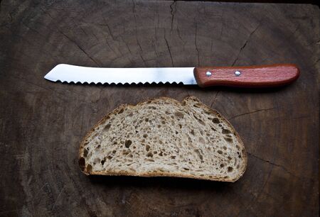 Slice of bread and knife on the boardの写真素材
