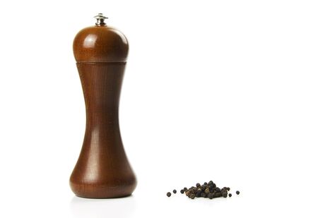 Pepper mill and black pepper on white backgroundの写真素材