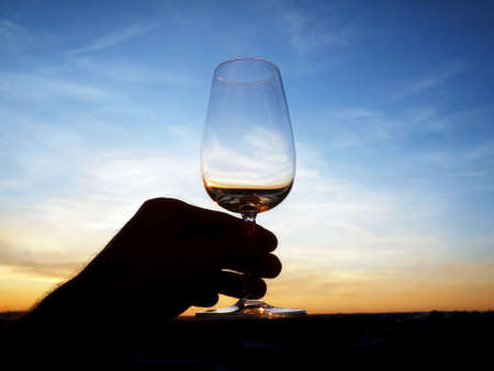 An empty glass of wine at sunsetの写真素材