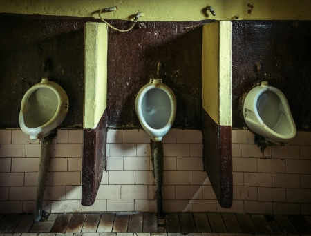 Three dirty urinals in public gents