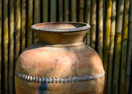 Big jar in a garden, bamboo wall background