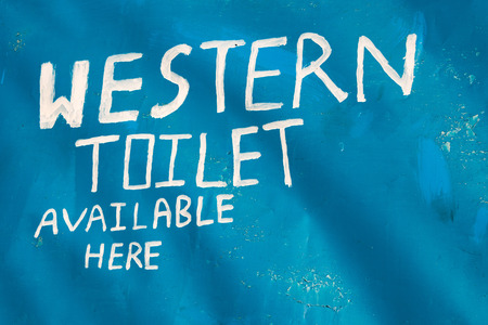Western toilet available here sign, painted in white on blue background
