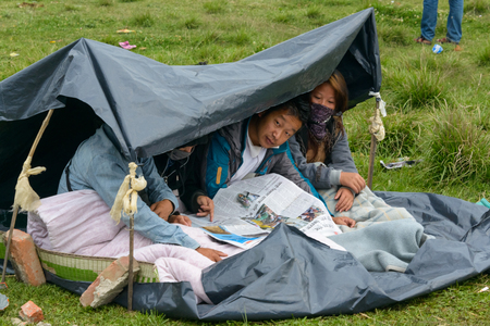 KATHMANDU, NEPAL - APRIL 26, 2015: People read the papers on an open ground at Chuchepati after their first night outside after the 7.8 earthquake on 25 April 2015.のeditorial素材