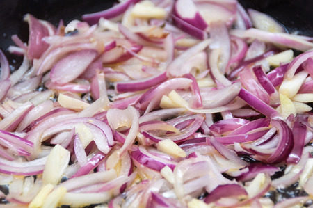 Cooking red onions and garlic in a panの写真素材