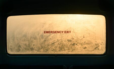 Emergency exit sign on a misty bus rear window