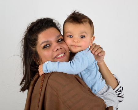 Smiling south asian mother holding her eurasian babyの写真素材