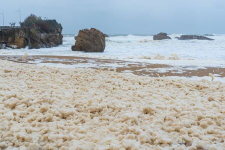 Foam on the Grande Plage beach and its quay during a storm, Franceの写真素材