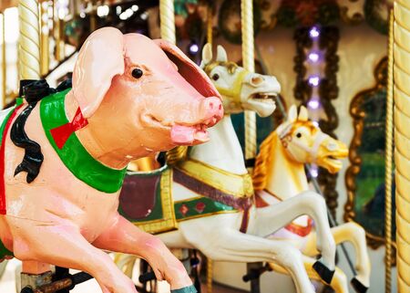 Bright pink pig and two horses at vintage carousel, retro feel and look.の写真素材