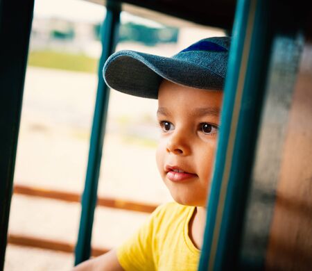 Little boy wearing blue cap portrait, outdoor settingの写真素材