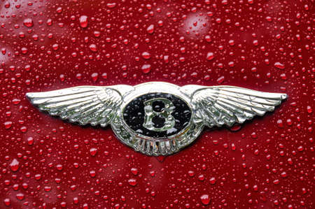 LONDON, UK - CIRCA SEPTEMBER 2011: Bentley logo on red car. Raindrops on bodywork and logo.のeditorial素材
