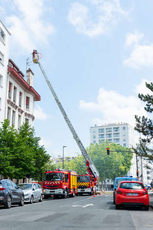 BAYONNE, FRANCE - 22 MAY, 2020: Firemen spray water to put out last floor apartment fire.のeditorial素材