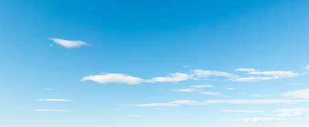 Panoramic blue sky background with small white clouds, summer or spring season. Beautiful weather concept.の写真素材