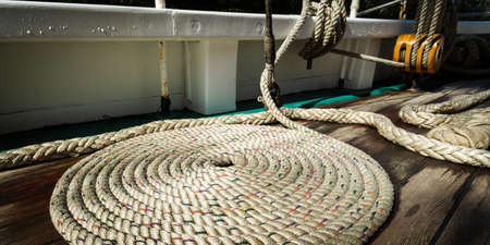 Sailboat nautical mooring rope on wet wooden deck, panoramic viewの写真素材