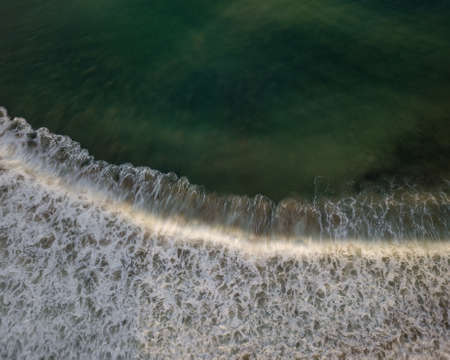 Top down aerial view of sea water and wave. Green ocean water and foam background with motion blur.の写真素材