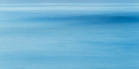 Long exposure of sea water and wave, full frame blue abstract background, shot at blue hourの写真素材