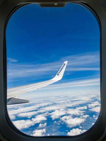 IN FLIGHT - CIRCA SEPTEMBER 2013: Ryanair airplane wing seen through plane window. Ryanair s an Irish low-cost airline founded in 1984.のeditorial素材