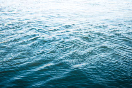 Rippled water surface background, gradient from dark blue to bright, water textureの写真素材