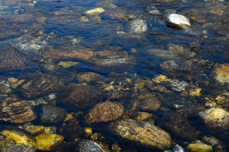 stones behind river with crystal water