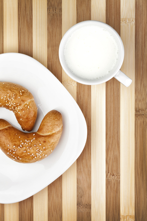 Two classic rolls served on white plate and with cup of yogurt. Photograph is taken from above. Studio shot.の写真素材