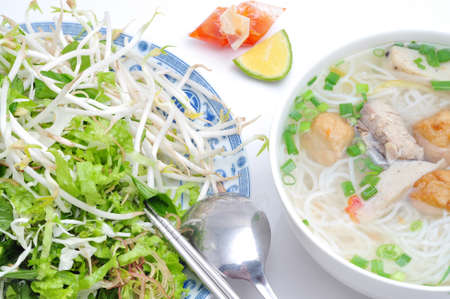 Bun cha ca or Vietnamese rice vermicelli with grilled fish and herbs on a white background