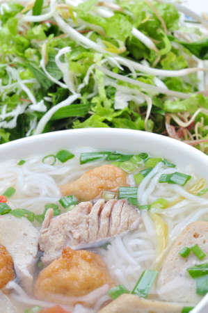 Bun cha ca or Vietnamese rice vermicelli with grilled fish and herbs on a white background