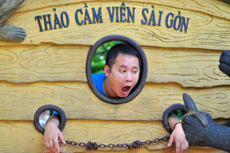 HO CHI MINH CITY, VIETNAM - NOVEMBER 2, 2014: A man is acting like an animal in the botanic garden of Sai Gonのeditorial素材