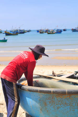 LAGI, VIETNAM - FEBRUARY 26, 2012: Local fishermen are preparing their fishing nets for a new working day in the Lagi beachのeditorial素材