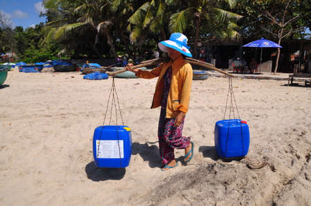 LAGI, VIETNAM - FEBRUARY 26, 2012: A local woman in Vietnam is taking fresh water to her fishing boat for a long day fishing in among the seaのeditorial素材