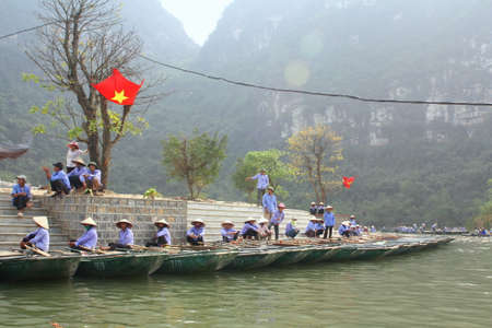 NINH BINH, VIETNAM - MARCH 29, 2010: Ferrymen are waiting for tourists to visit the Trang An Eco-Tourism Complex, a complex beauty - landscapes called as an outdoor geological museumのeditorial素材