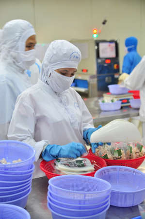 VUNG TAU, VIETNAM - DECEMBER 9, 2014: Workers are packaging product for export in a seafood factory in Vietnamのeditorial素材