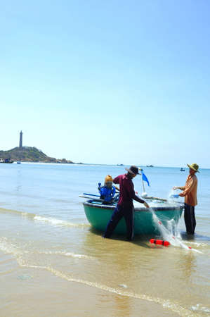 LAGI, VIETNAM - FEBRUARY 26, 2012: Local fishermen are preparing their fishing nets for a new working day in the Lagi beachのeditorial素材