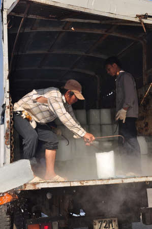 CON DAO, VIETNAM - JULY 2, 2012: Porters are shaving ice at the local seaport of Con Dao island of Vietnamのeditorial素材