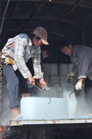 CON DAO, VIETNAM - JULY 2, 2012: Porters are shaving ice at the local seaport of Con Dao island of Vietnamのeditorial素材