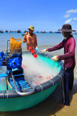 LAGI, VIETNAM - FEBRUARY 26, 2012: Local fishermen are preparing their fishing nets for a new working day in the Lagi beachのeditorial素材