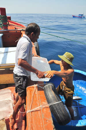 NHA TRANG, VIETNAM - MAY 4, 2012: Transferring supplements from land to fishing boats in the sea of Nha Trang bayのeditorial素材
