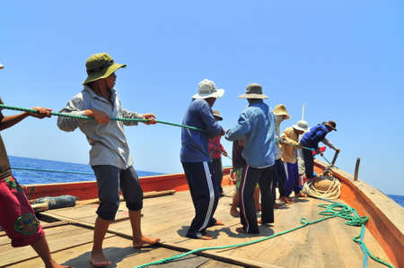 NHA TRANG, VIETNAM - MAY 5, 2012: Fishermen are catching tuna with a trawl net.のeditorial素材