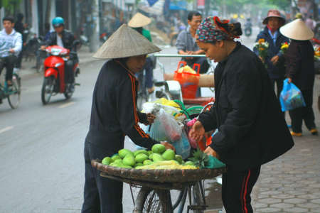 NAM DINH, VIETNAM - MARCH 30, 2010: Street vendor of fruits on a pavement in Nam Dinh cityのeditorial素材