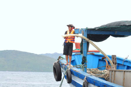 NHA TRANG, VIETNAM - JUNE 23, 2013: Feeding barramundi fish by machine in cage culture in the Van Phong bay in Vietnamのeditorial素材