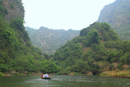 NINH BINH, VIETNAM - MARCH 29, 2010: Ferrymen are taking tourists to visit the Trang An Eco-Tourism Complex, a complex beauty - landscapes called as an outdoor geological museumのeditorial素材