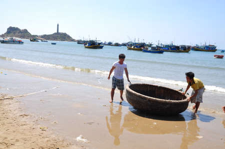 LAGI, VIETNAM - FEBRUARY 26, 2012: Local fishermen are preparing their basket boat for a new working day in the Lagi beachのeditorial素材