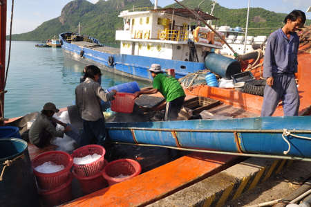 CON DAO, VIETNAM - JULY 2, 2012: Porters are shaving ice at the local seaport of Con Dao island of Vietnamのeditorial素材