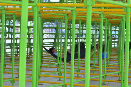 Nha Trang, Vietnam - July 11, 2015: Workers are sleeping under construction scaffoldings in the...