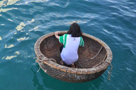 Nha Trang, Vietnam - July 14, 2015: A girl is ready for racing by basket boats in the sea of Nha Trang bayのeditorial素材