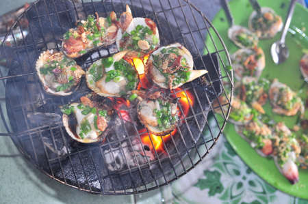 Grilling shellfish and seafood on hot fireの写真素材